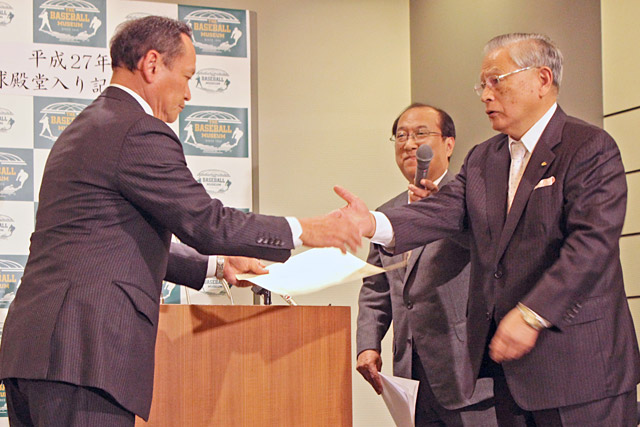 表彰を受け、熊﨑氏と握手をする林清一氏