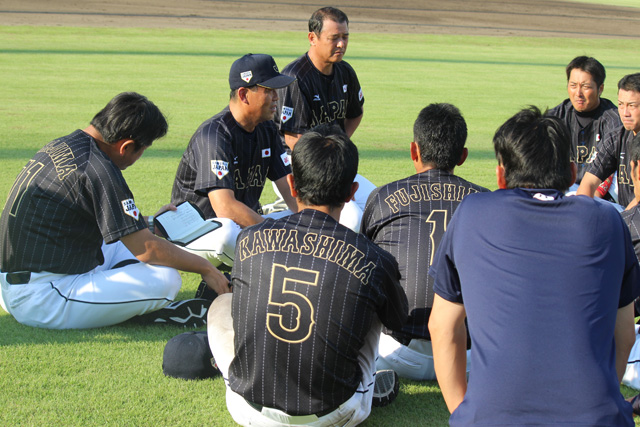 試合後、外野でミーティングする選手たち
