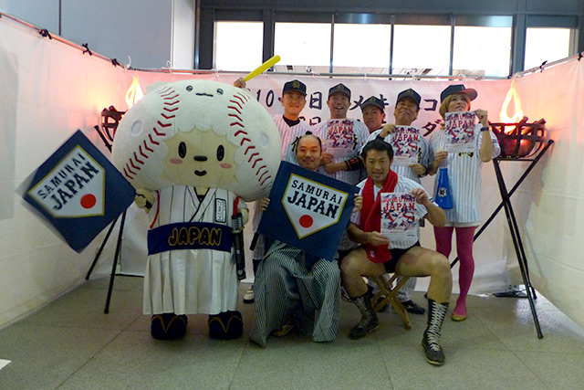 侍ジャパン強化試合のチラシを手にするたまベヱ(左)お侍ちゃん(中央)偽ジャパンの面々