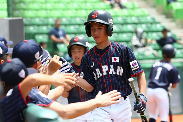 3回 ホーム生還しハイタッチする永田晃庄(長崎南リトルリーグ)