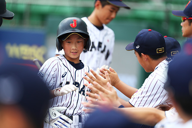 ホーム生還しハイタッチする高畑知季(兵庫波賀リトルリーグ)