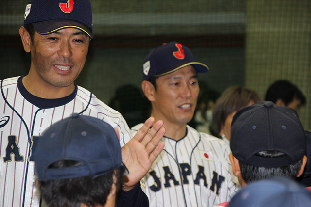 ハイタッチで見送る稲葉篤紀督と井端弘和コーチ