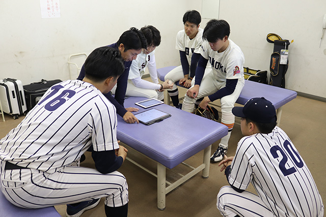 投球の測定値のフィードバックを受ける選手たち