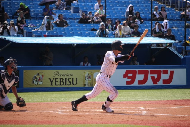 右中間を破る三塁打を放つ小島大河(明治大)