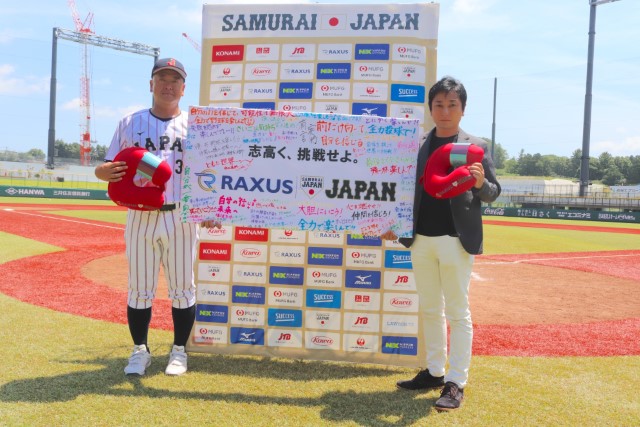 ラグザス株式会社の福重生次郎社長からメッセージフラッグとネックピローを受け取る大久保秀昭監督
